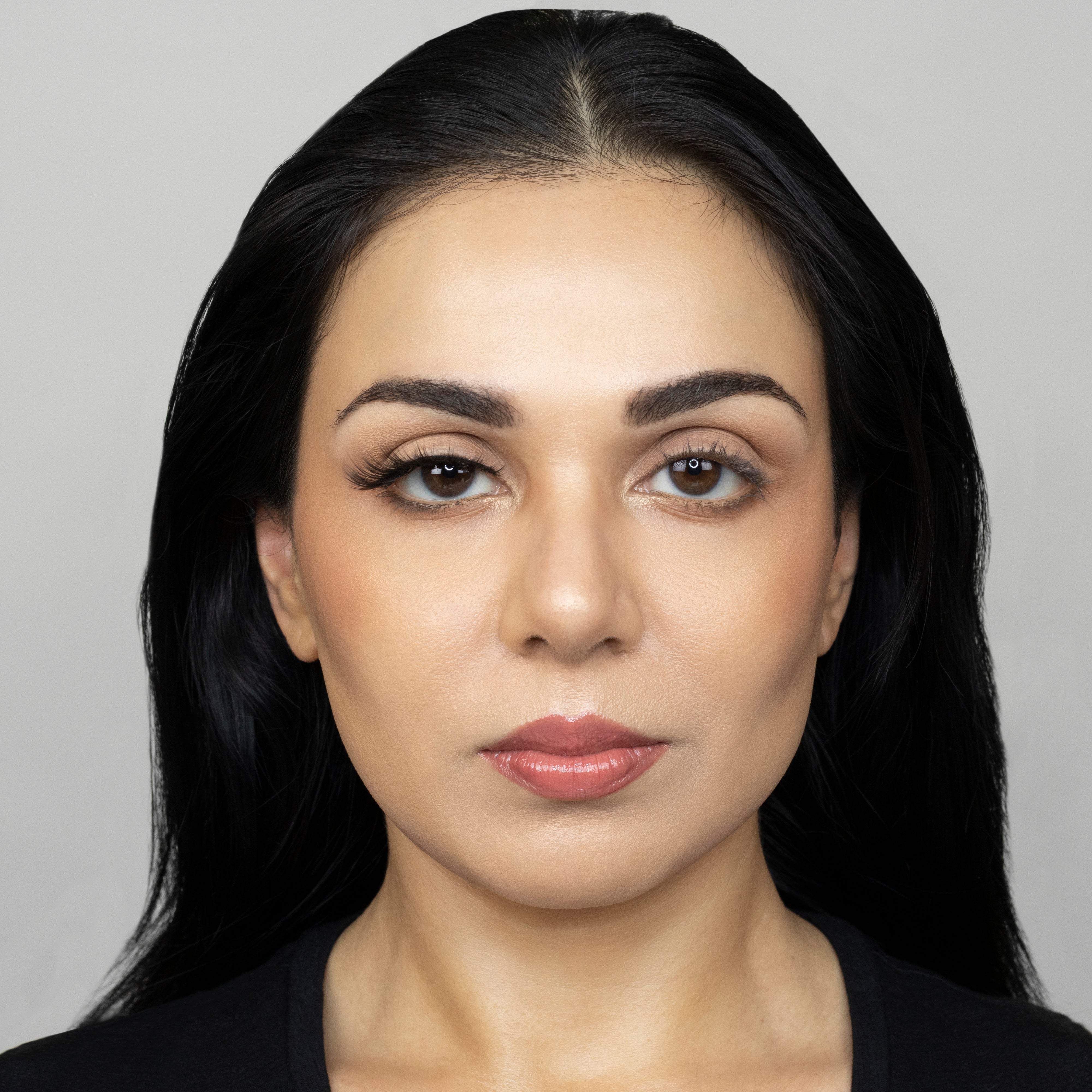 Full face of young beautiful woman wearing Suntarah Beauty Premium Synthetic Strip Eyelash in Style S-222 on right eye only.  There is a significant difference in appeal between both her eyes.  Her right eye is subtlely accentuated with a wispy, sexy, cat-eye like false strip lash.  