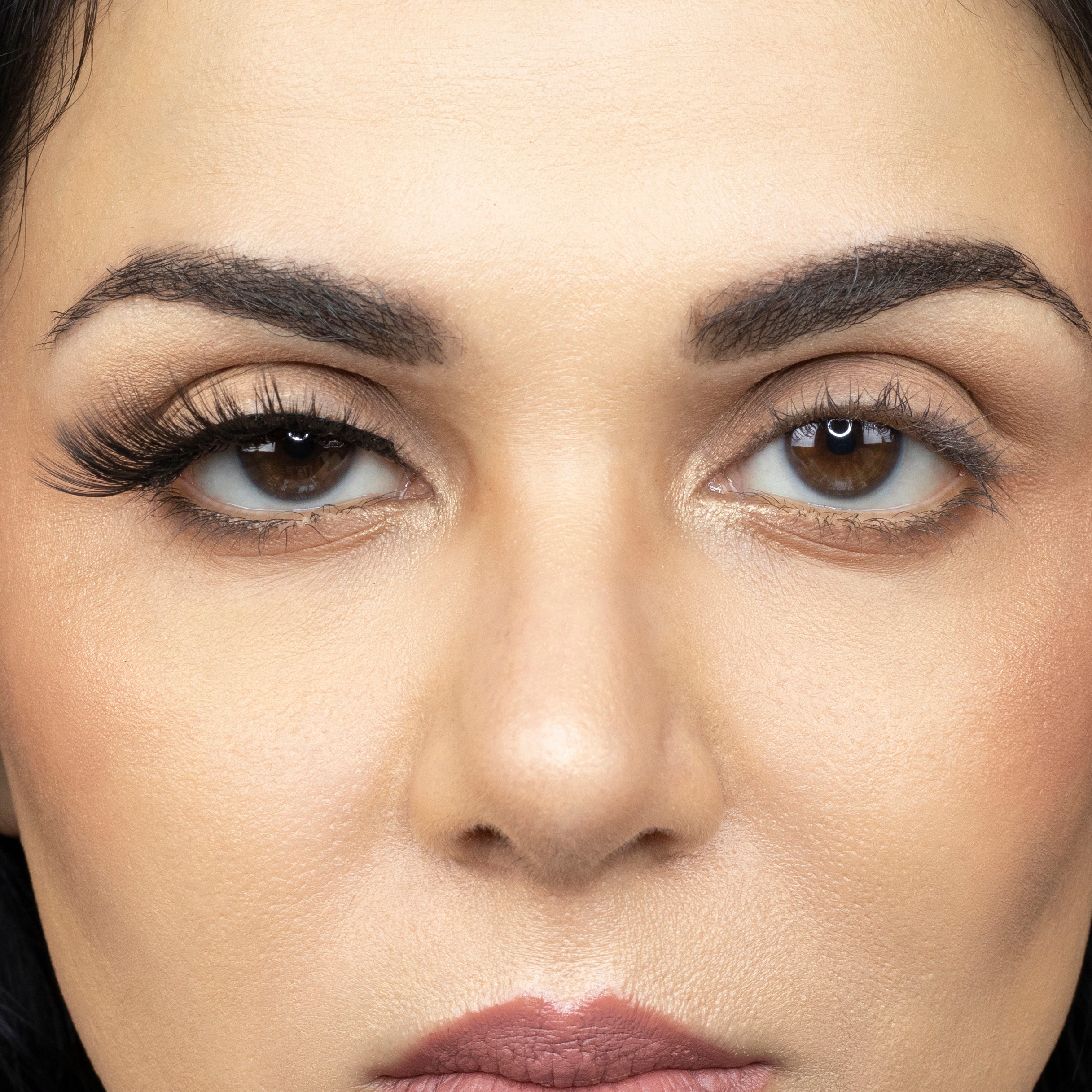 Close up picture of young woman wearing Suntarah Beauty 3D Premium Synthetic Strip Eyelash in Style S-224 on right eye only. There is a significant difference between her eyes. Her right eye looks very sensual and foxy. False lash looks wispy and sultry.