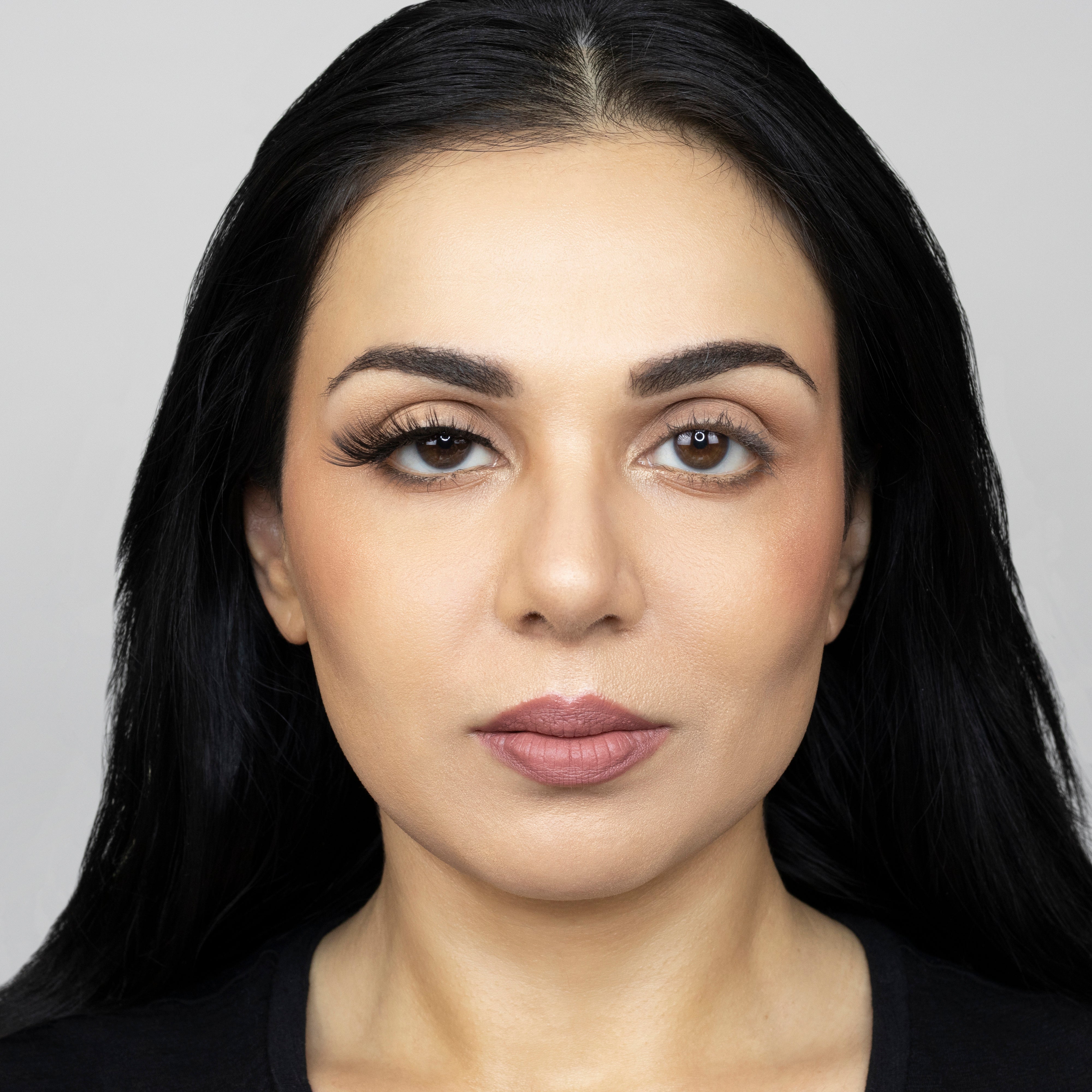 Full face of young beautiful woman wearing Suntarah Beauty Premium Synthetic Strip Eyelash in Style S-224 on right eye only. There is a significant difference between her eyes. Her right eye is accentuated with a sensual, foxy, and glamorous false strip lash.