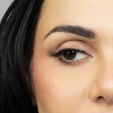 Close up of woman’s right eye while wearing Suntarah Beauty 3D Ultra Light Synthetic false strip eyelash in style SL-332.  Woman is looking to the side.  